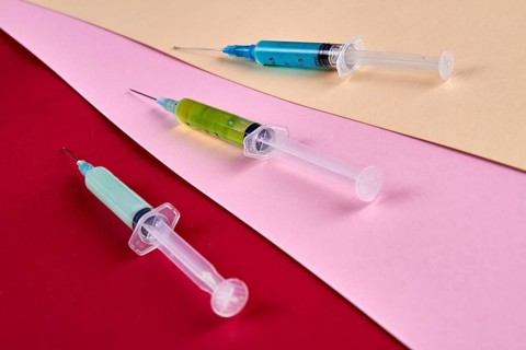 Close-up three syringes filled with multicolored medicine liquids. Drugs addiction and injections