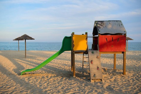 Landscape and playground on island Corsica with wicker parasols