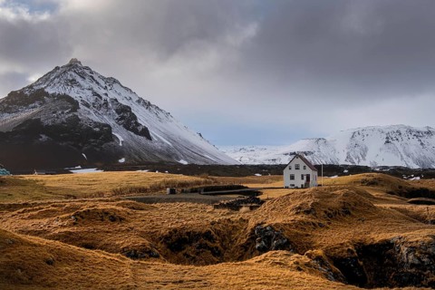 Lonely house on the basalt coast and Stapafell mountain near the snfellsjoekull glacier,