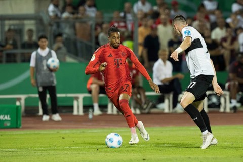 Football match, Michael Akpovie OLISE FC Bayern Munich left on the ball in a duel with Niklas KOLBE