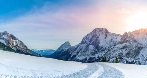 Winter landscape with a road made by a snowmobile, its traces through the layer of snow, in the