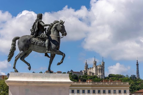 Large equestrian statue of Louis XIV on a pedestal on Place Bellecour and in the background