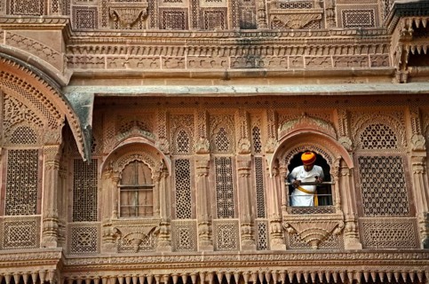Man peeping out of palace window at Mehrangarh Fort, Jodhpur, Rajasthan, India, Asia