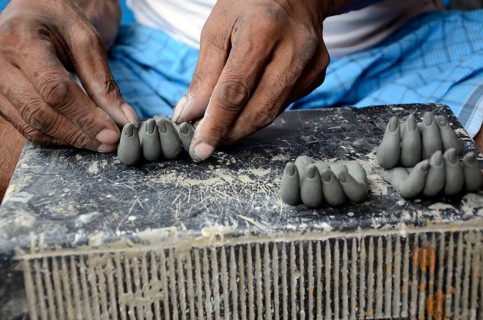 Man making fingers of clay, Kumartuli, Kolkata, West Bengal, India, Asia