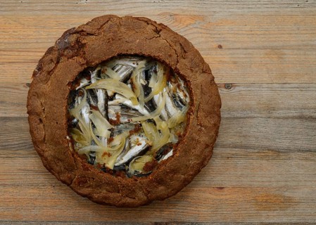 Traditional Finnish rye pie with vendace on a wooden table