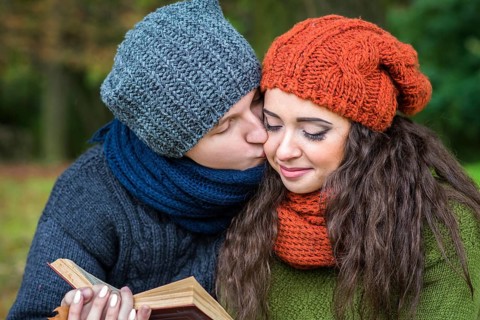 Loving couple reads a book in the autumn garden