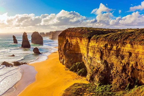 Rocks of the Twelve Apostles at sunset. Powerful Pacific surf breaks down on the shore. Grandiose