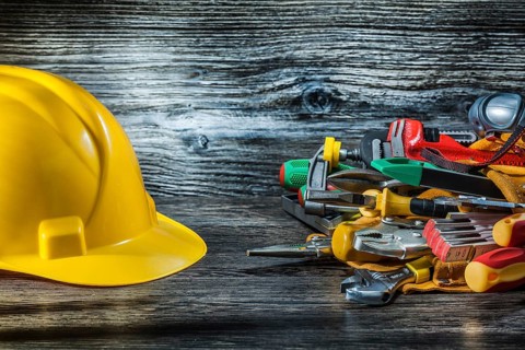 Construction helmet and set of tools on vintage wood