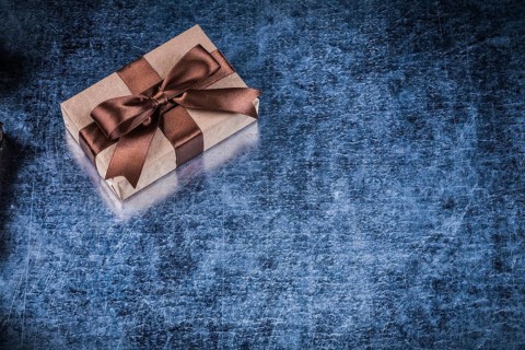 Present box with bow on scratched metallic background holidays concept