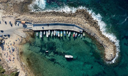 Aerial drone view of fishing boats moored at the harbor. moored at breakwater. Peyia, Cyprus