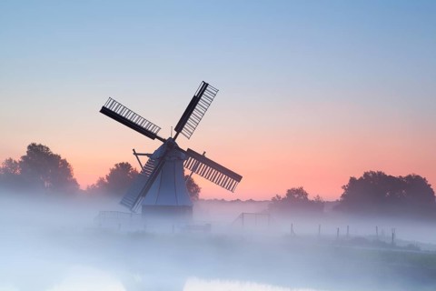 Charming Dutch windmill in morning sunrise fog, Groningen, Netherlands