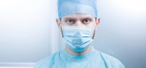 Doctor looking directly at the camera in a clean medical environment
