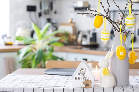 Key to house of cozy home with Easter decor with rabbit and eggs on table of kitchen. Building,