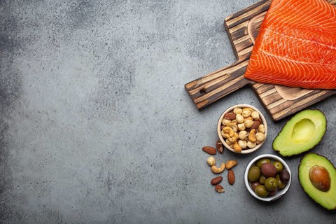 Food sources of healthy unsaturated fat and omega 3: fresh raw salmon fillet, avocado, olives, nuts
