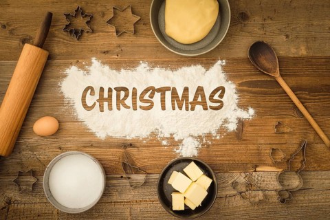 Collection of ingredients and utensils for baking Christmas biscuits with the word Christmas