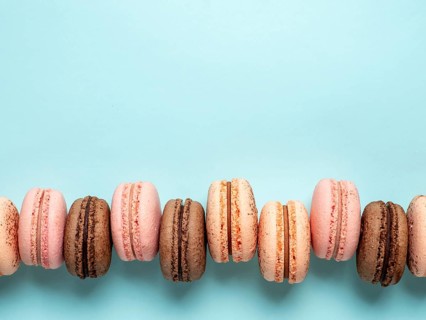 Macarons with copy space. Row of perfect french macarons or macaroons on blue background. Top view