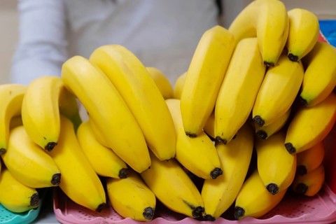 A pile of yellow ripe bananas on a shop counter