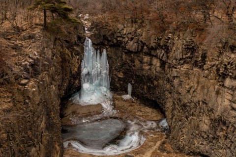 Looking down on frozen waterfall in deep crater located in Gyeonggi province of South Korea