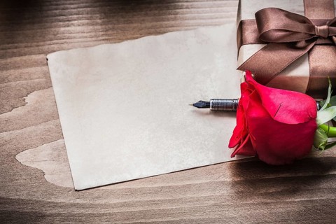 Red rose giftbox sheet of paper fountain pen holiday concept