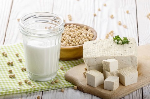 Non-dairy alternatives Soy milk or yogurt in mason jar and tofu on white wooden table with soybeans