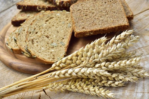 Cereal, wheat and bread on a wooden table. Different types of bread on wood