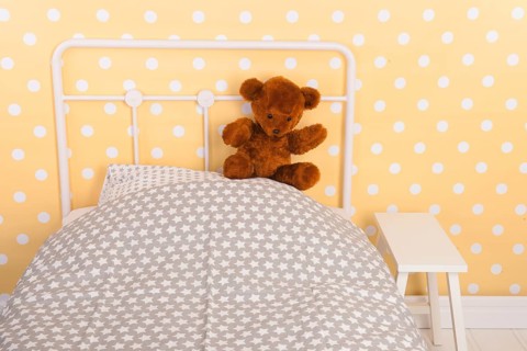 Bedroom with teddy bear sitting on bed