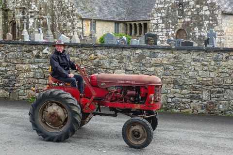 Old tractor Massey Ferguson in front of church and chapel Sainte Nonne, vintage car meeting