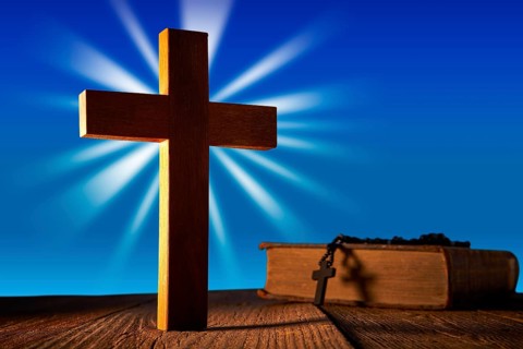 Christian wood cross on blue sky wooden made with Bible and rosary beads