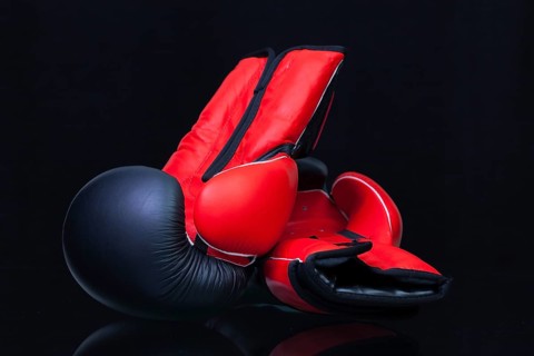 Red and black boxing gloves on black glass table