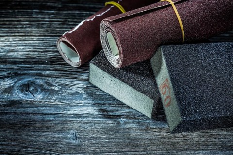 Rolled abrasive paper sponges on vintage wooden board
