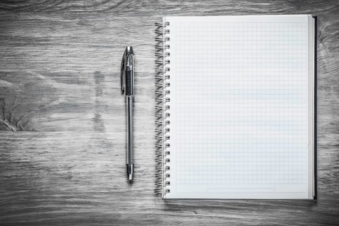 Squared copybook pen on wooden board education concept