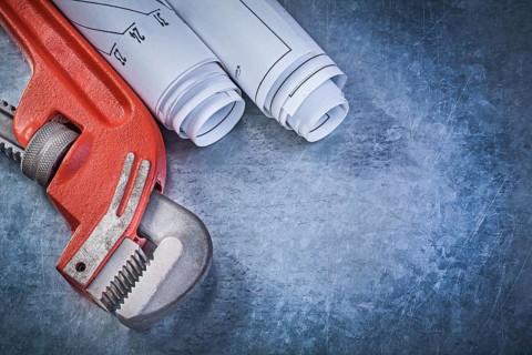 Monkey wrench rolled engineering drawings on metallic background plumbing concept