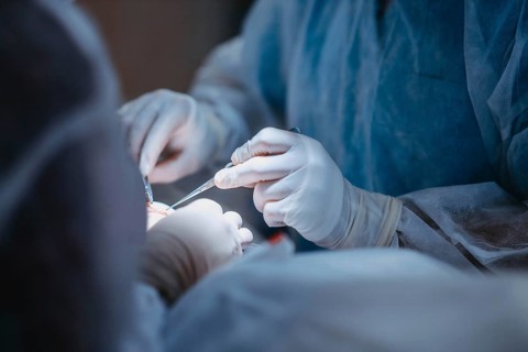 Medical professionals use tools during a surgical operation, emphasizing precision and teamwork
