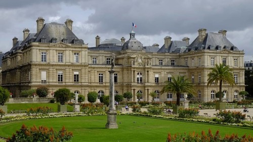 Jardin du Luxembourg with lawns, borders and planters. The Palais du Luxembourg in the background.