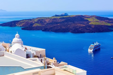 Santorini, Greece iconic view of white houses, church dome, caldera, volcano island and sea