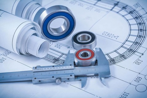 Rolls of construction plans rolling bearings and slide caliper on blueprint industrial concept