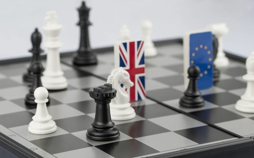 Chess pieces and flags of the European Union and the UK on a chessboard. The concept of the