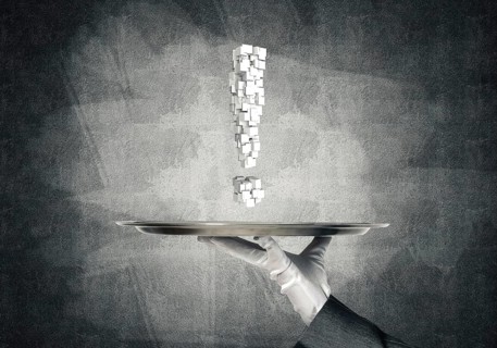 Cropped image of waitress's hand in white glove presenting multiple cubes in form of exclamation