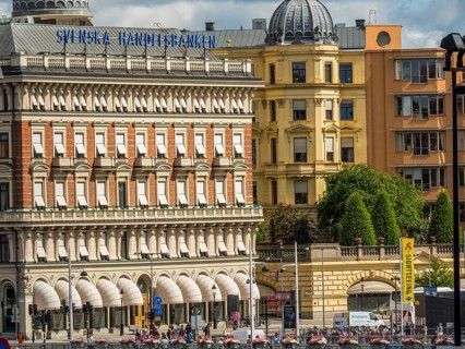 A row of architectural buildings with advertising signs and a cloudy sky above, stockholm, baltic