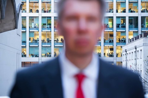 Defocussed businessman looking at the camera at dusk