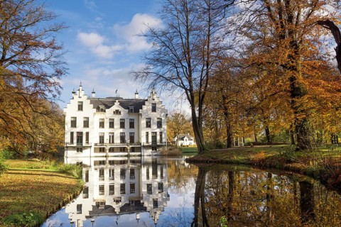 Castle Staverden reflecting in the moat and surrounded by autumn colored trees
