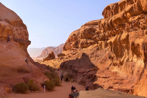 Wadi Rum, Jordan, November 1, 2022: Desert landscape with orange sand and rock formations, people