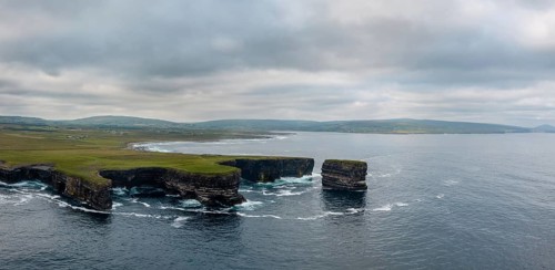 A drone panorama landscape of the Downpatrick Head sea stack and cliffs and coastline of northern