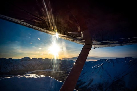 View from an aeroplane of a snow-covered mountain landscape at sunset, Yukon, Canada, Whitehorse
