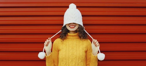 Winter christmas portrait of happy cheerful young woman smiling having fun in yellow sweater, white