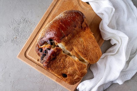 Wheat flour bread with raisins on a wooden board