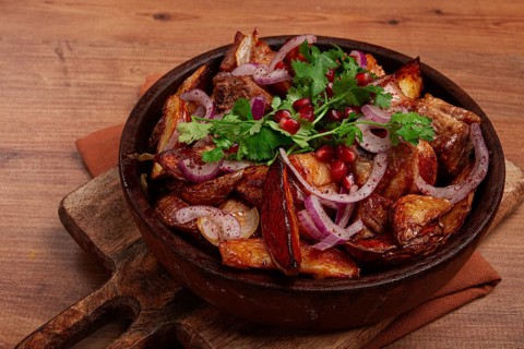 Ojakhuri, a traditional Georgian dish, fried potatoes with meat, in a clay pan, top view, without