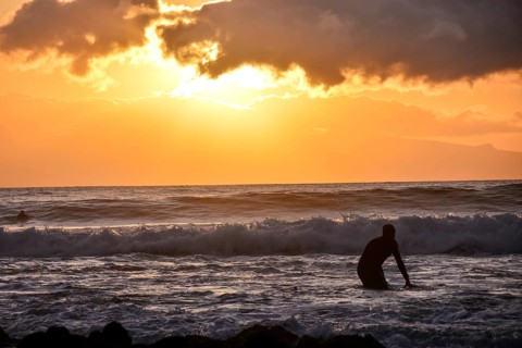 Single surfer at sunset on a calm ocean