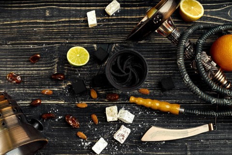 Arabic hookah with a tobacco flavor of a mixture of citruses. Top view of a dark wooden background.