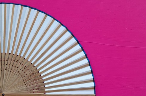 Typical Japanese hand fan made on the wooden pink table